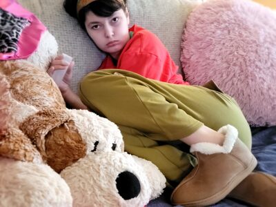 girl on couch sitting on navy peapod incontinence mat