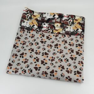 Pillowcase with pattern of dog paw prints on a light grey background border fabric of happy dogs