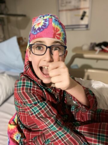 Child wearing tie dye NillyNoggin EEG Cap