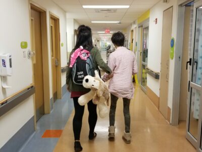 mom and daughter walking in emergency room at hospital