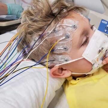boy getting eeg with electrodes and leads visible