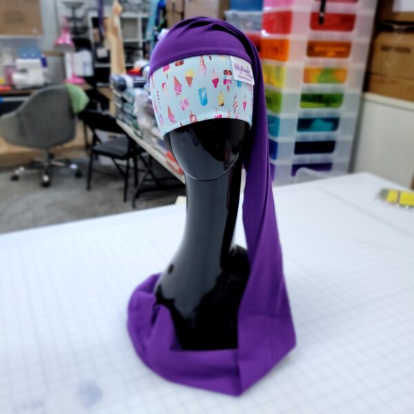 nillynoggin eeg cap on a black mannequin head with an ice cream band and long purple length