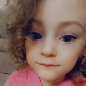 little girl with beautiful eyes in pink shirt with curly hair